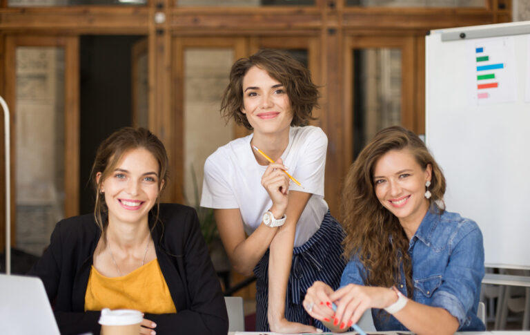Young cheerful women happily looking in camera while spending ti
